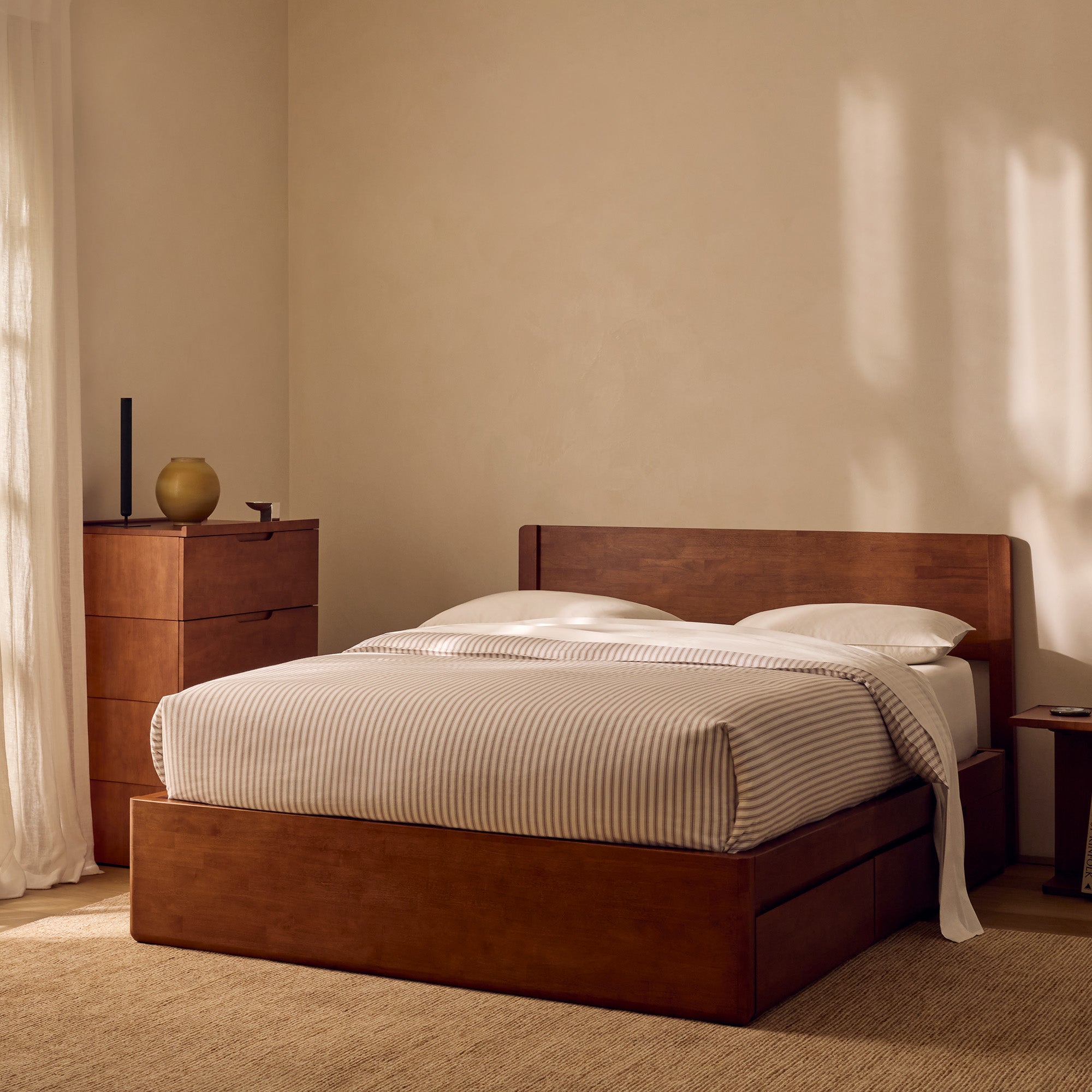 Wooden bed with striped bedding in a bedroom setting